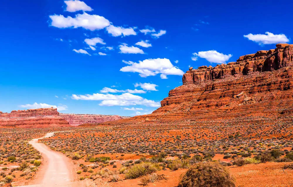 road in desert surrounded by red rock formations