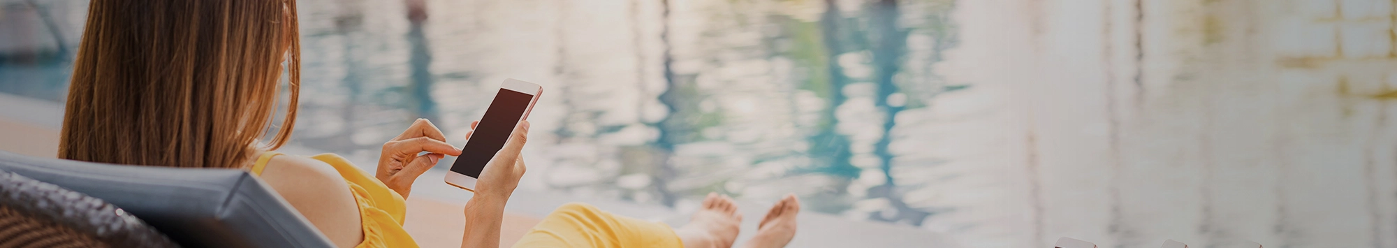 woman on phone next to pool