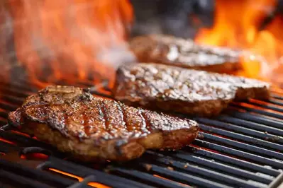 steaks on a grill flaming 